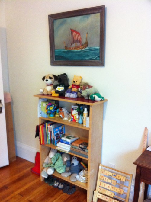 Maple bookshelf with toys and viking painting