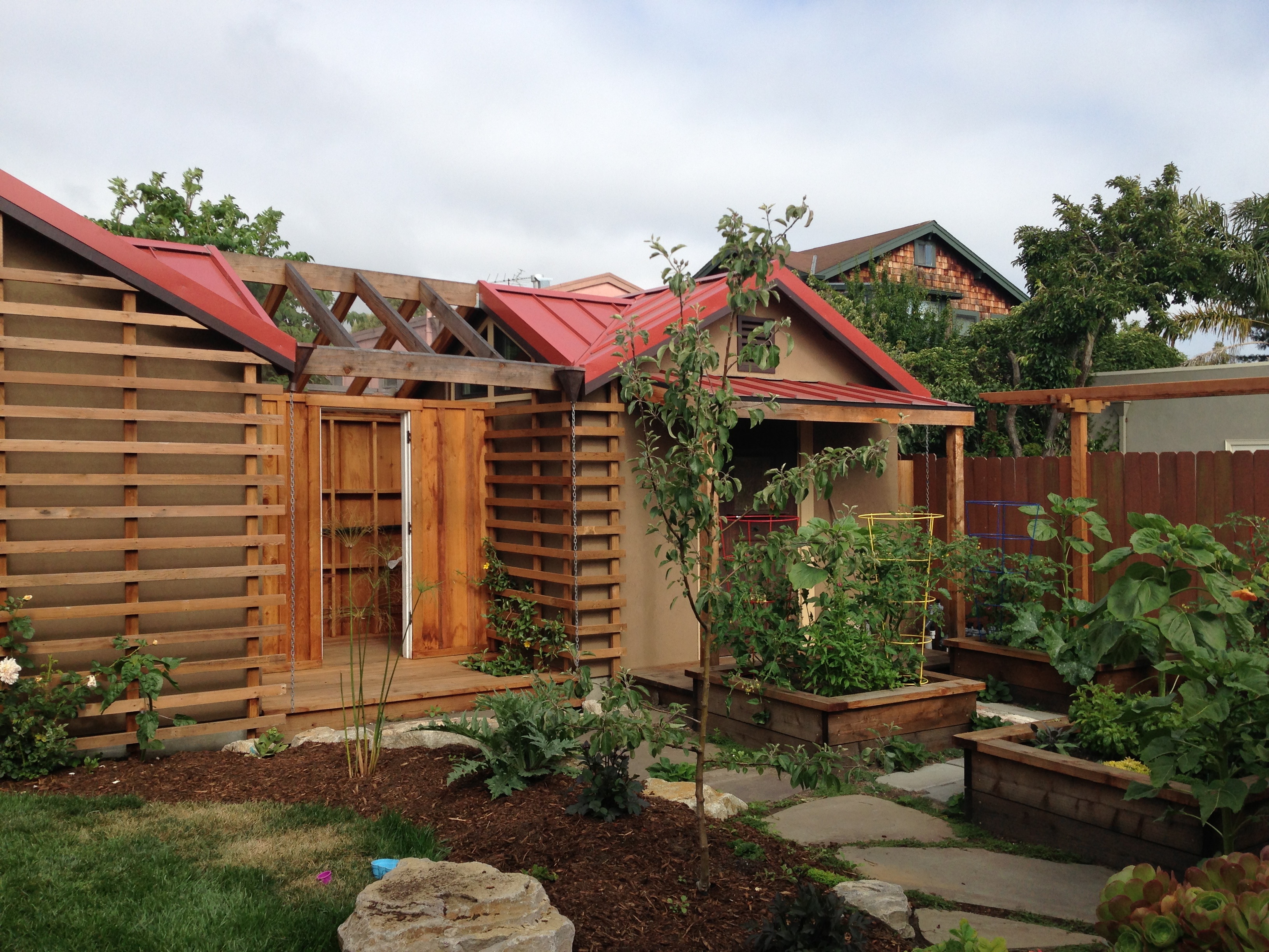 trellises, vegetable beds, and roses and vines starting to climb